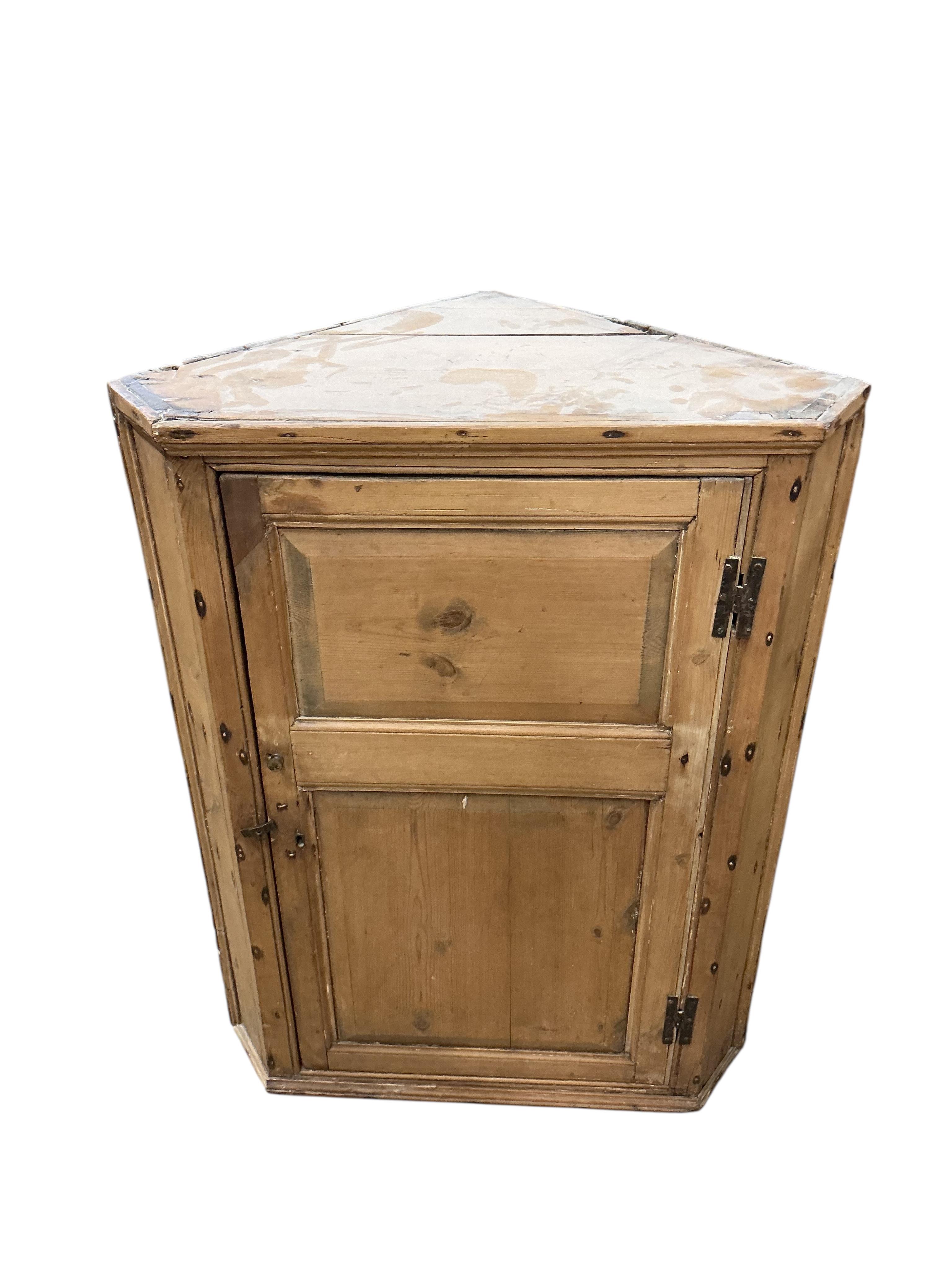 An early 19th century pine hanging corner cupboard, width 67cm, depth 43cm, height 88cm